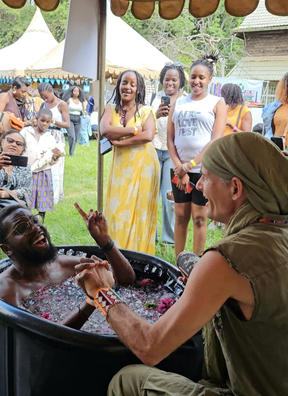 A guest sings in a flower-filled ice bath as friends gather around.